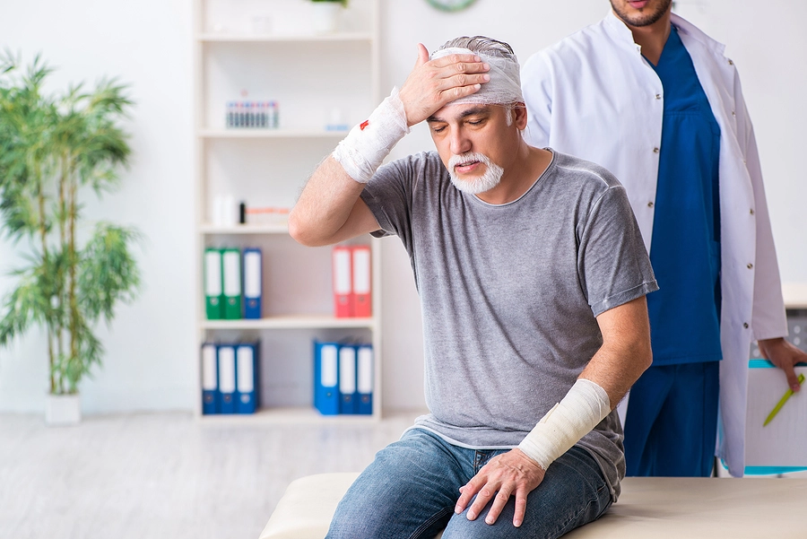 Accident victim with multiple traumatic injuries to his head and arms at the doctor